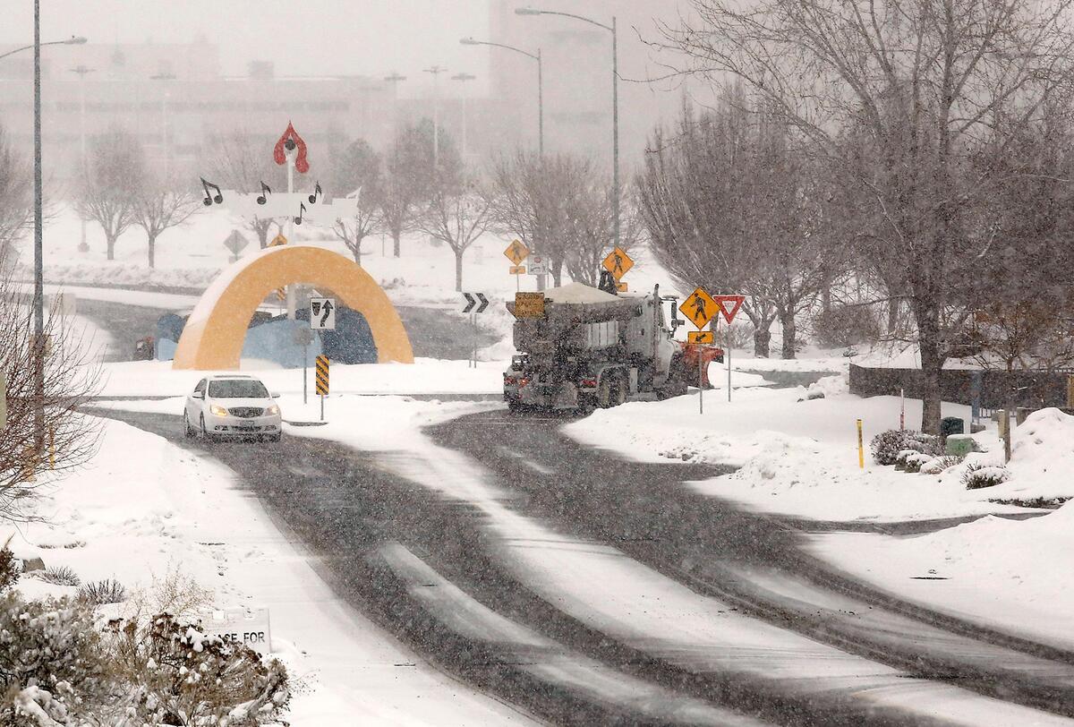 A City of Kennewick snowplow enters the traffic roundabout on North Young Street and West Grandridge Boulevard during Monday’s winter storm.