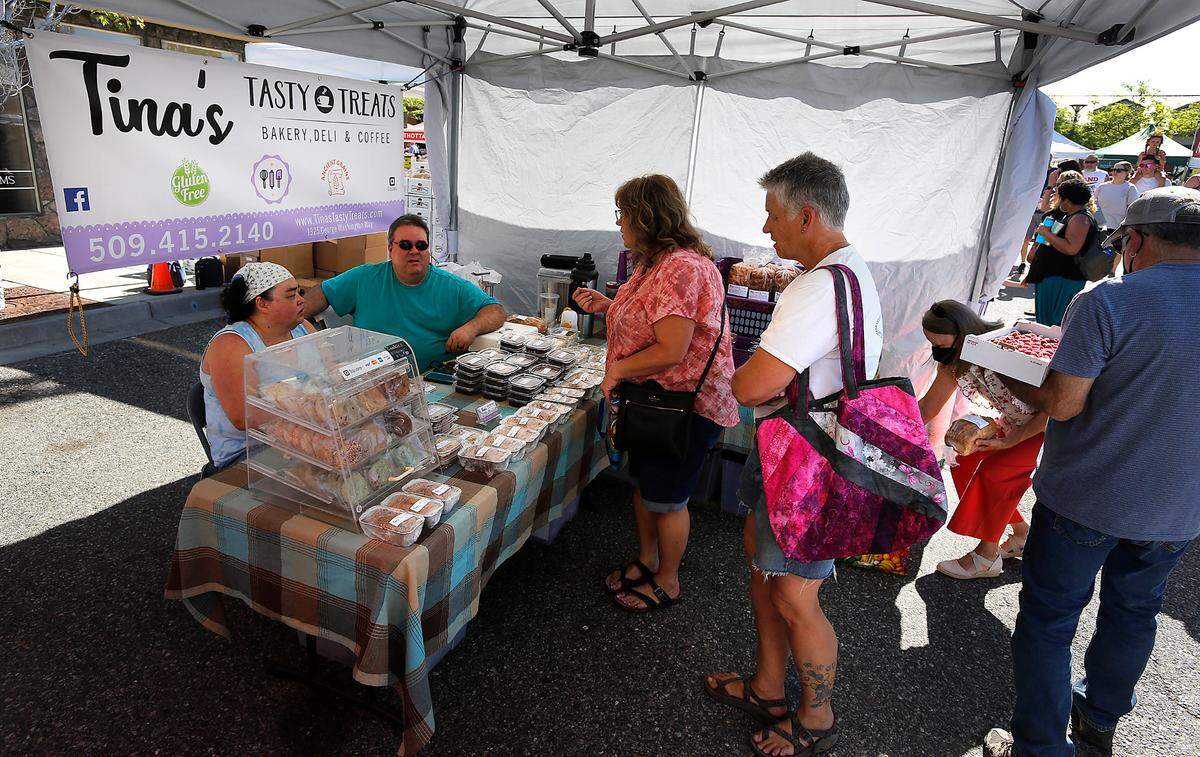 Tina and Shawn Pack talk with customers buying their gluten-free bakery items for sale at their booth called Tina’s Tasty Treats at the Richland Farmer’s Market on The Parkway in Richland.