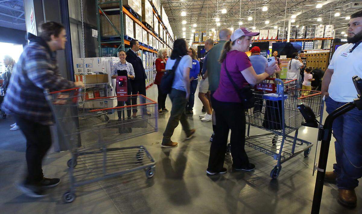 Members enter the store after the doors opened to customers following a brief grand opening ceremony Friday morning for the new Costco.
