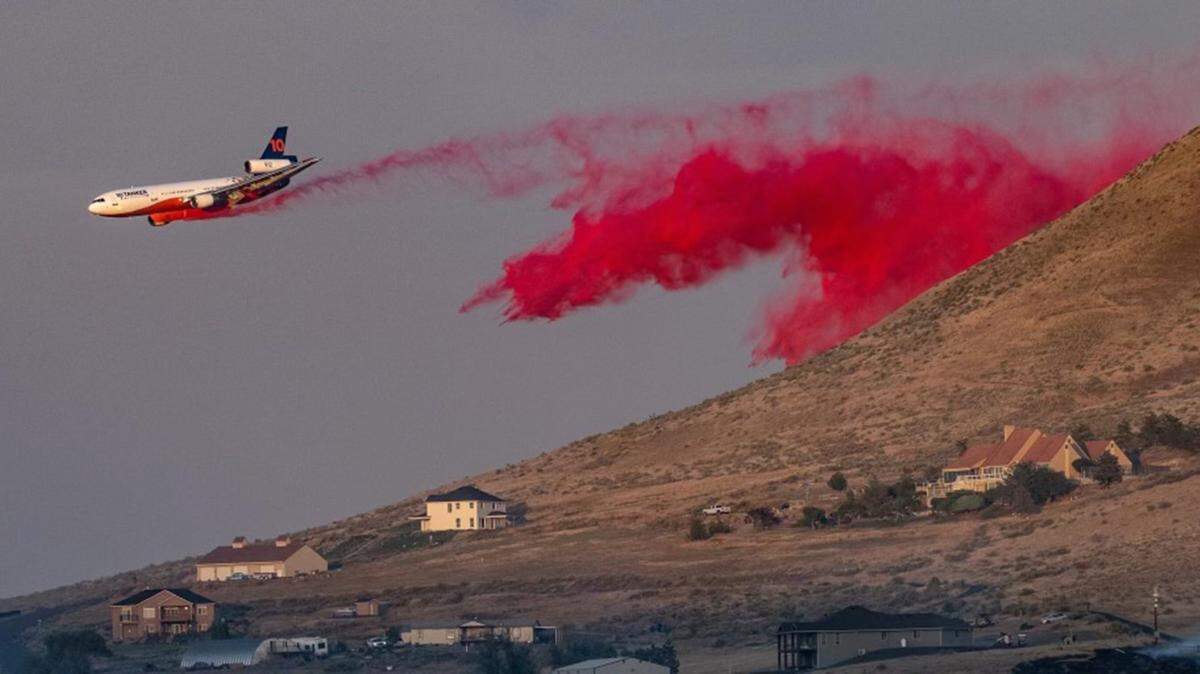 An air tanker drops a load of fire retardant Tuesday night on the large brush fire that broke out near Ruppert Road north of Benton City. It burned 150 acres.