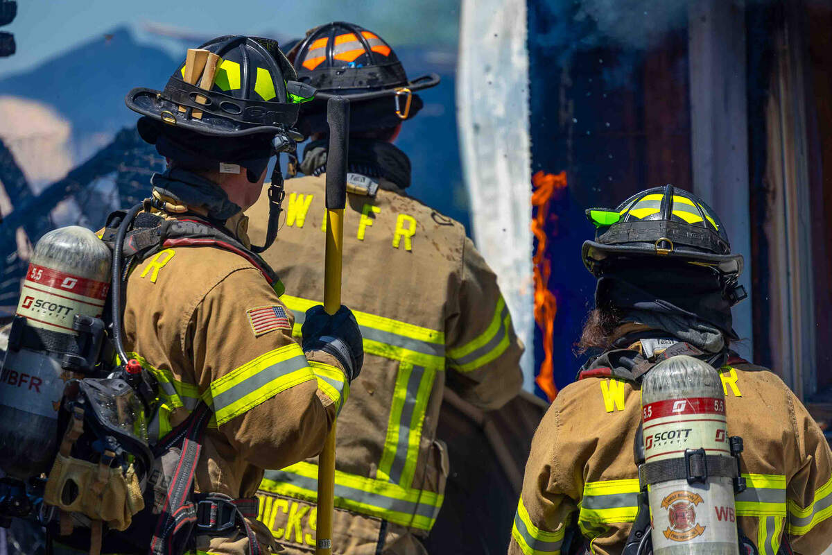 Firefighters work on extinguishing a fire at a farm near Prosser.