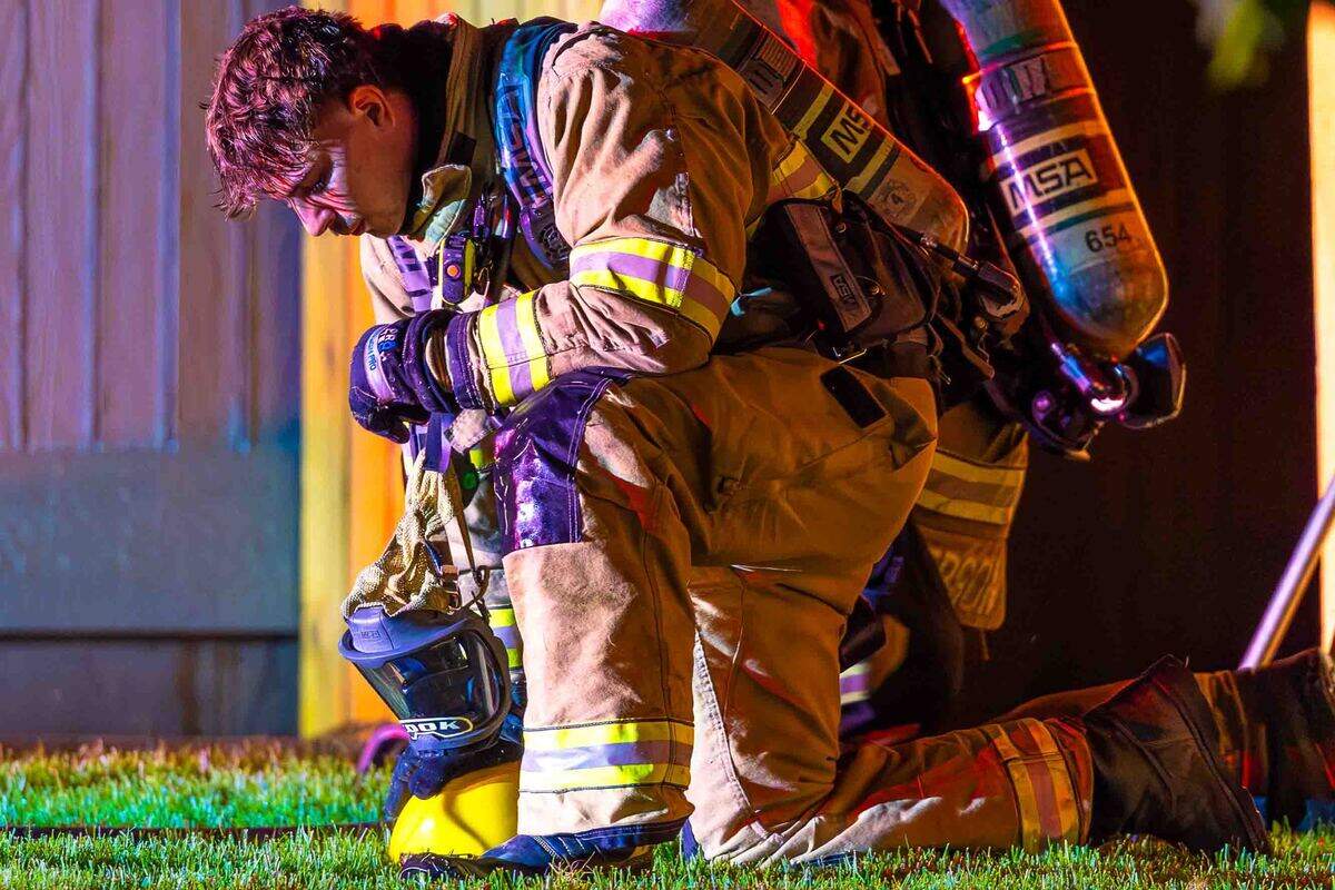 A firefighter pauses after working an early morning residential fire in the 5200 block of Jacksnipe Court on Sunday in West Richland.