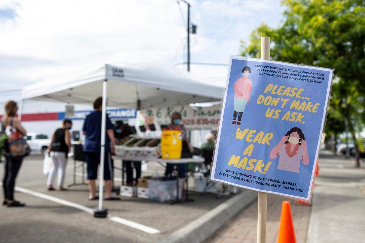 A sign in Kennewick urges people to wear masks and maintain social distance. The Kennewick Farmer’s Market is open 4 to 7 p.m. Thursdays through October at the Flag Plaza in downtown.