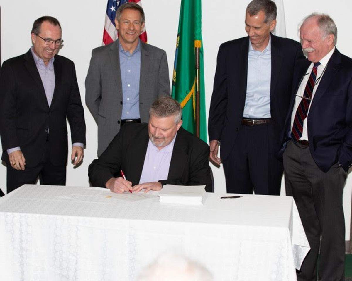Ben Harp, the Department of Energy Office of River Protection deputy manager, signs a Safety Evaluation Report which recommended approval of the Hanford vitrification plant's safety analysis. From left are Brian Reilly, Bechtel National project director; Rob Hastings, ORP assistant manager for technical and regulatory support; Brian Vance, ORP manager; and Alan Dobson, Bechtel National area manager for nuclear safety.