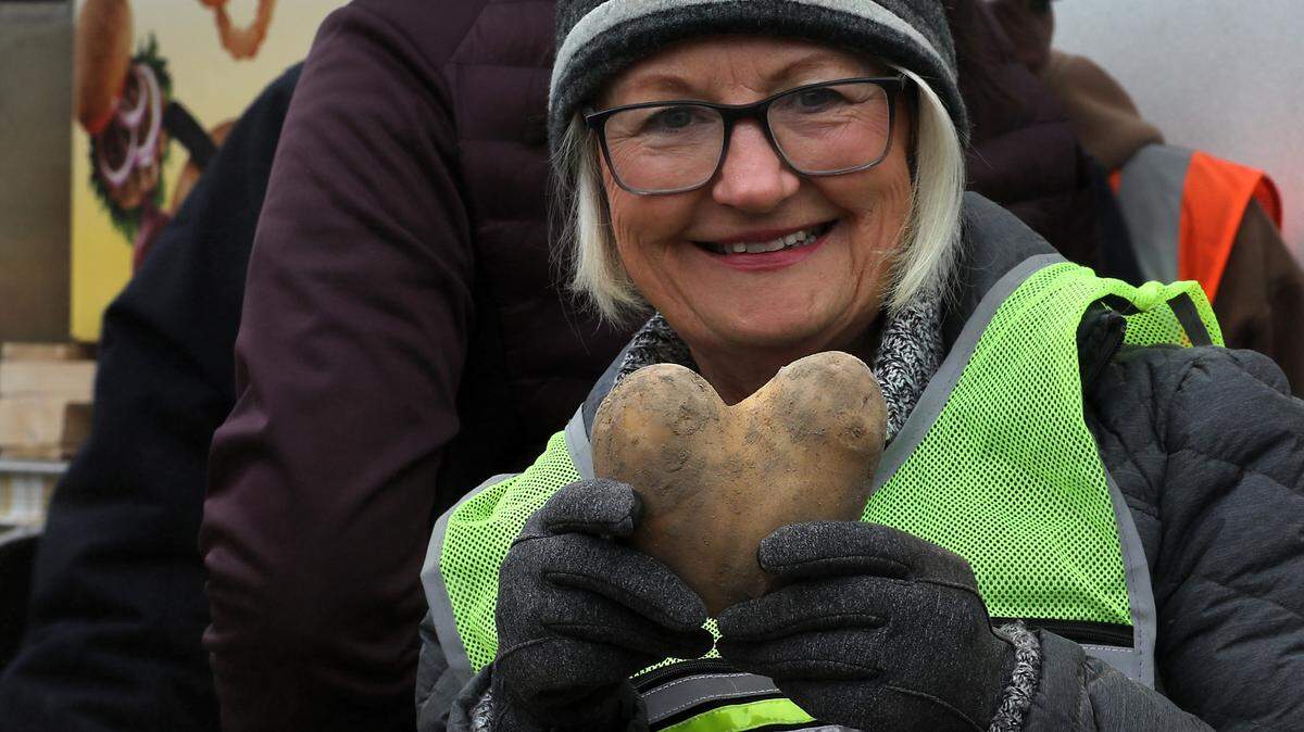 A volunteer holds up a heart-shaped potato she discovered while bagging and sorting produce Friday morning for the 2nd Harvest Mobile Market event held in the parking lot of the LifeChurch7 in Richland. About 50 volunteers from the church and Energy Northwest were on hand to help give out free food for about 250 Mid-Columbia families.
