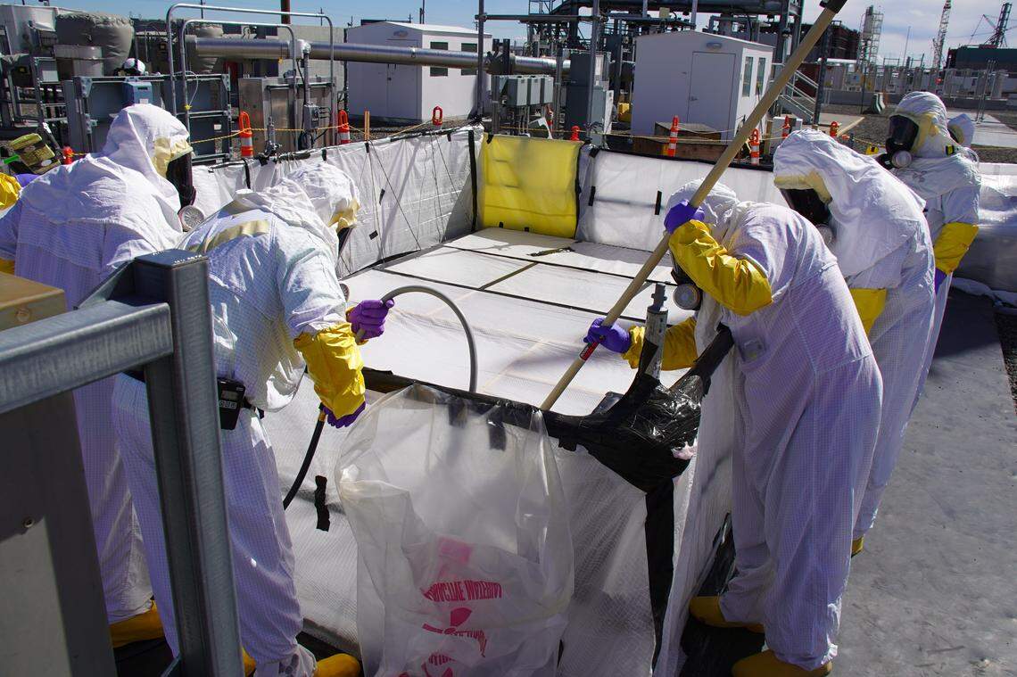 Workers with Hanford Tank Waste Operations & Closure (H2C) use long reach tools to tighten nozzle connectors while installing the final piece of piping needed to connect the tank farms to the vitrification plant.                            
