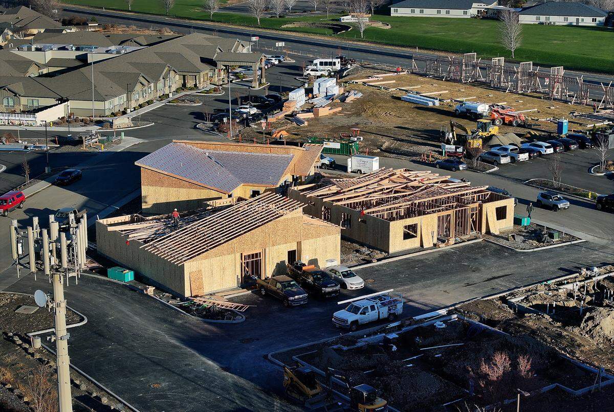 Construction workers place roof trusses for the Quillan Place Senior Villas in south Kennewick.