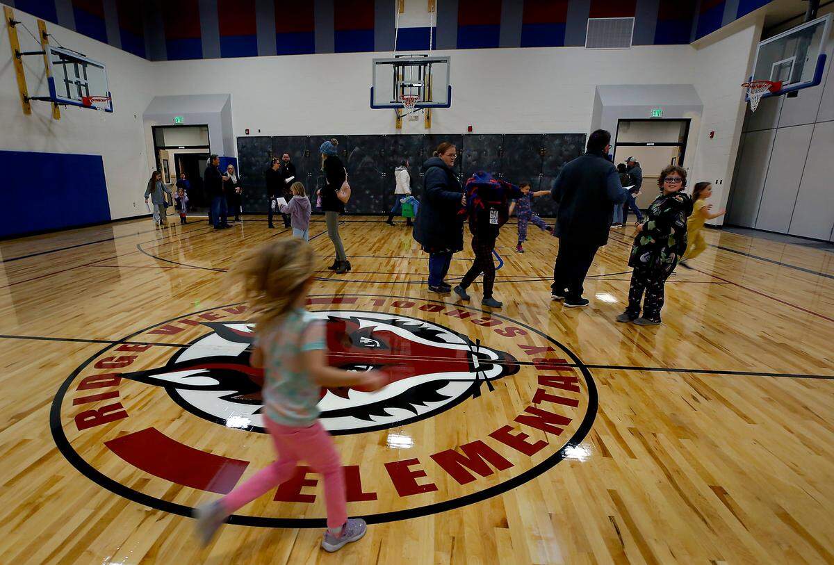 Students run around the gymnasium as part of a special family-only sneak peek event of the new $31 million Kennewick school.