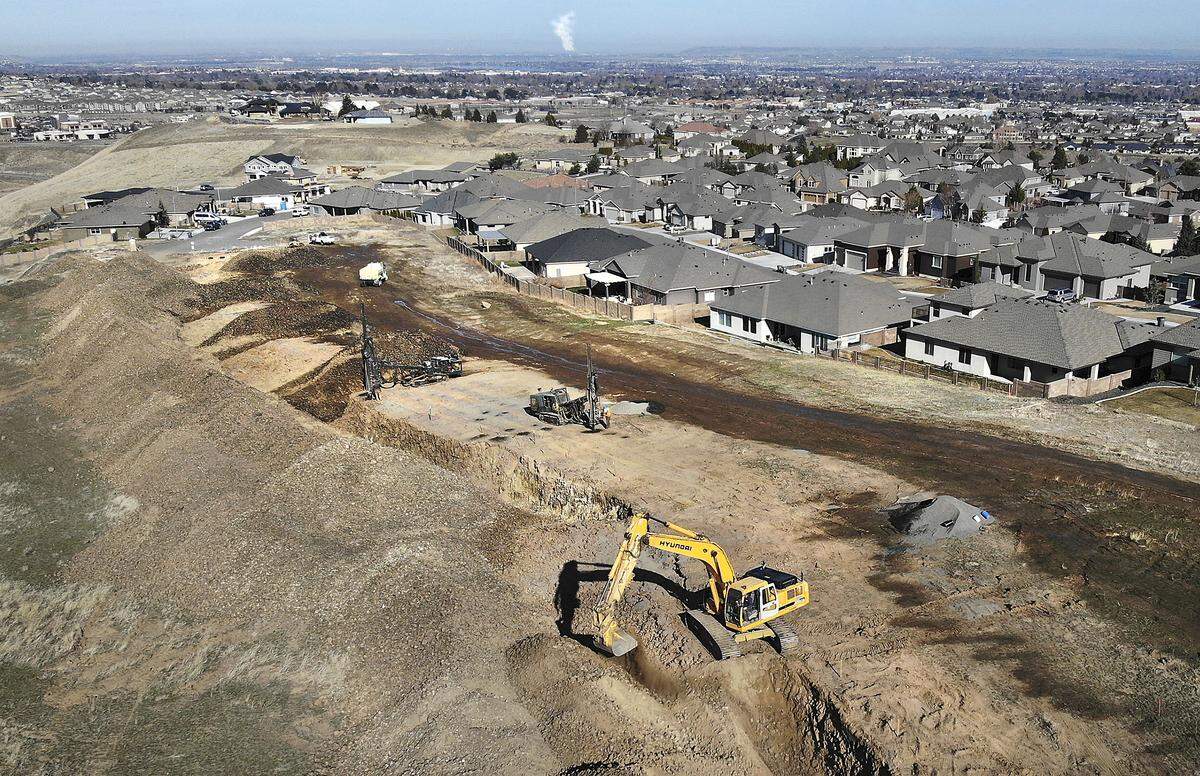 An excavator and drilling machines work in a field behind homes on West 48th Avenue near South Reed and Olson Streets at the south end of The Heights at Canyon Lakes neighborhood in Kennewick. Homeowners say their houses are being damaged from blasting being used by developer Ron Asmus to excavate the rocky ground and have asked the city council to order a stop it. Watch a video at: tricityherald.com/videos