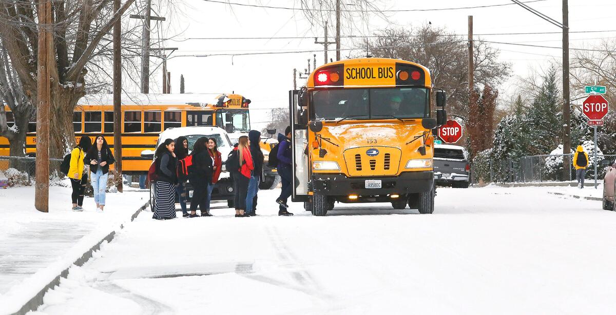 Pasco School District students board their buses after a two-hour delay because of winter weather conditions Tuesday morning on West B Street near South 5th Avenue.