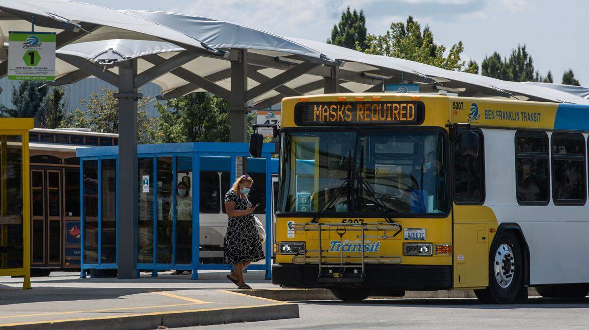Ben Franklin Transit bus flashes a “Mask Required” message across the front reader board as passengers board at the Three Rivers Transit Center bus station in Kennewick.