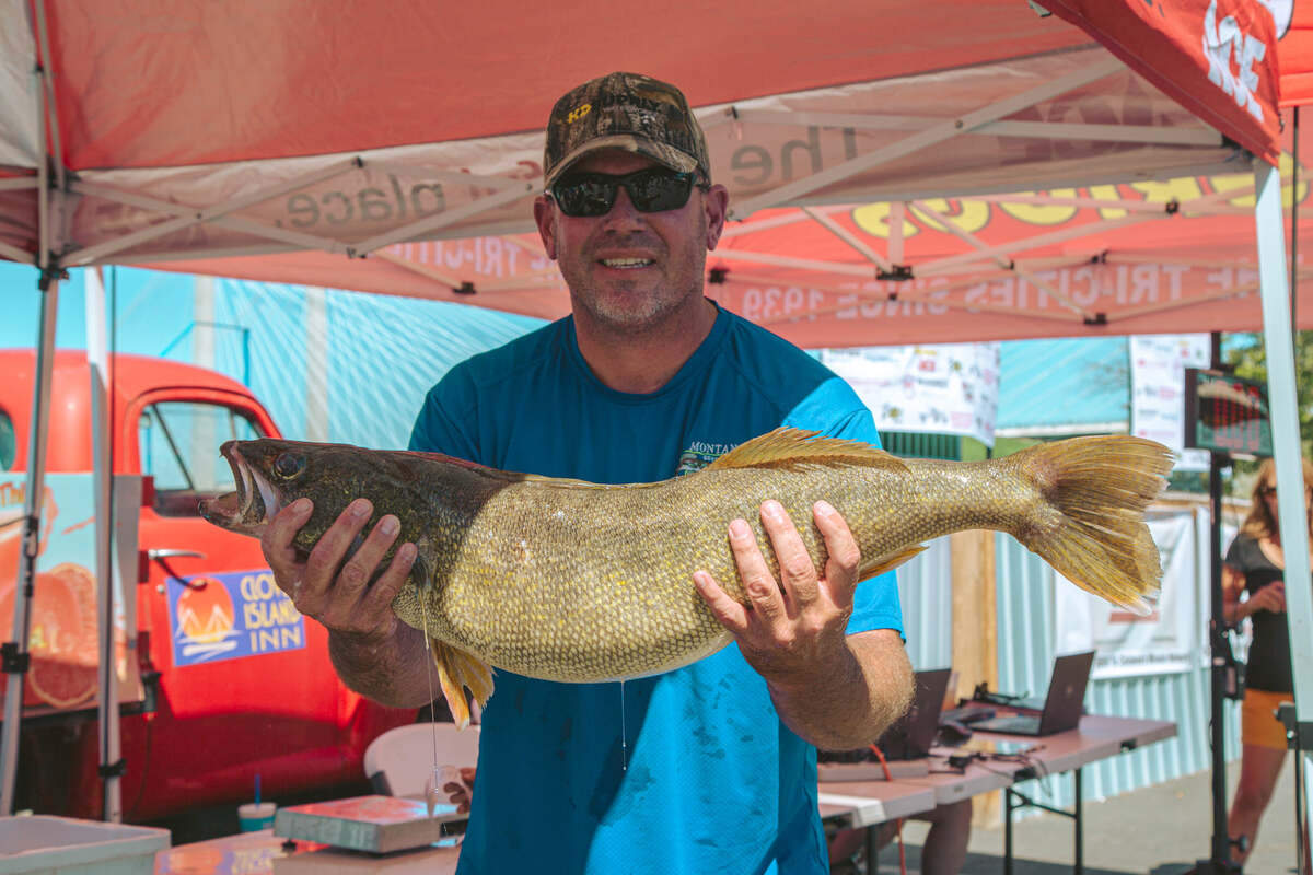 An angler shows off his catch at the 2021 Children’s Miracle Network walleye fishing tournament, held at Clover Island.