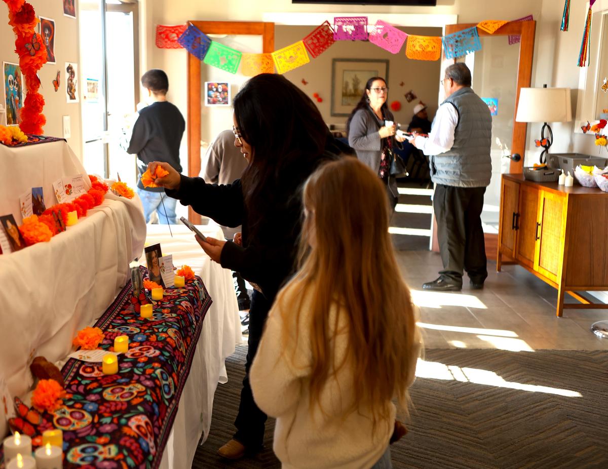Kayla Heredia and stepdaughter Aubrey, left, decorate a section of community altar at Einan’s at Hillcrest Pasco.