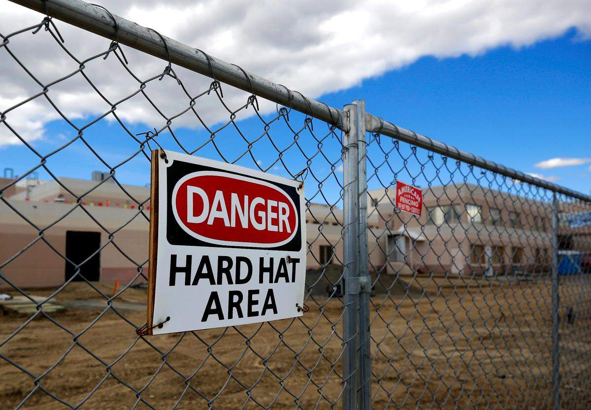 Temporary fencing surrounds the former Kennewick General Hospital as construction crews work on gutting the first floor of the facility. The building renovation for the new Columbia Valley Center for Recovery facility is being designed and constructed by Bouten Construction and NAC Architecture.