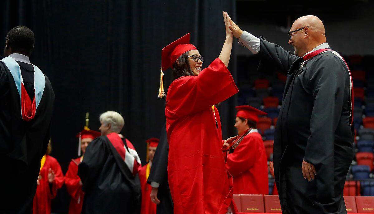 Kamiakin graduation Zoe Arambul high fives Principal Chris Chelin after receiving her diploma during Saturday’s graudation ceremony at the Toyota Center in Kennewick.