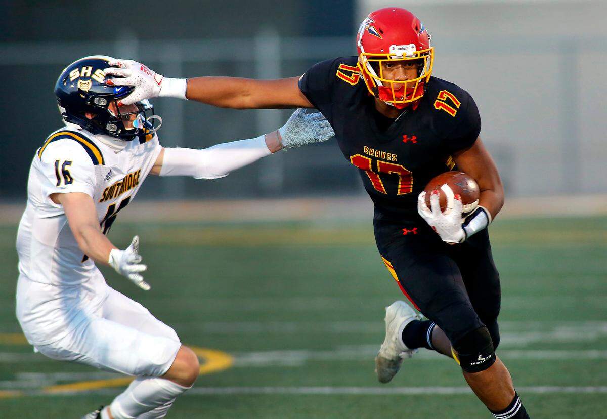 Kamiakin’s Messiah Jones (17) uses a well-placed stiff arm against Southridge defender Brendan Beckwith (16) for extra yards during Friday night’s game at Lampson Stadium.
