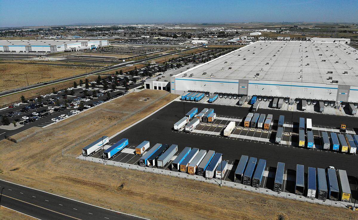 Employee vehicles and delivery trucks fill the parking lot at one of two Amazon Inc. warehouses in Pasco in August 2024.