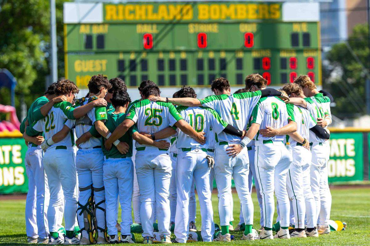 Richland Bombers players and coaches stand along the first baseline during pregame ceremonies on Memorial Day weekend before opening-round play against the Skyline Spartans at the WIAA 4A State Baseball Championships Saturday at Bomber Bowl in Richland.