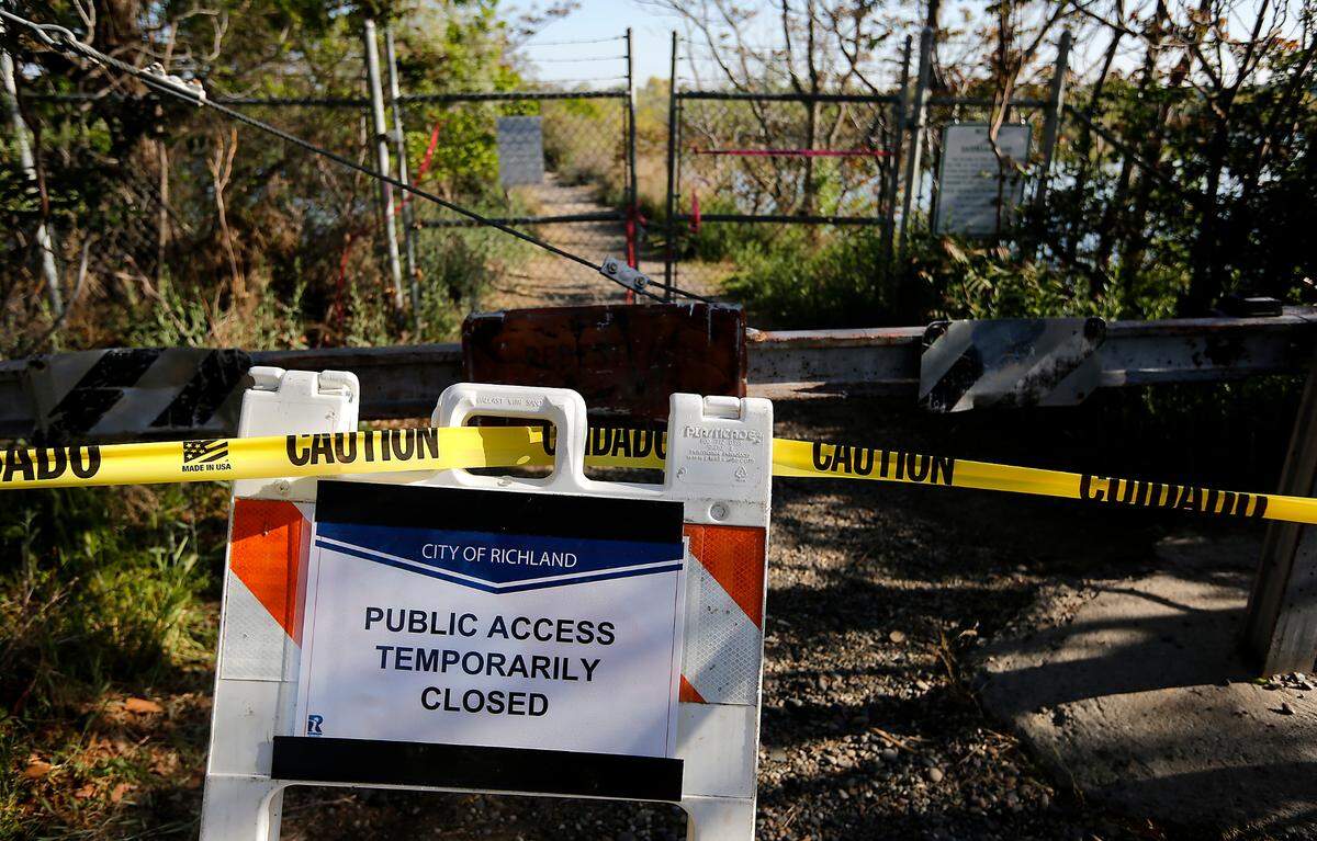 Signs, caution tape and a closed gate temporarily restrict access to Bateman Island at the causeway to the island at the confluence of the Yakima and Columbia Rivers in Richland.&nbsp;The city of Richland posted to its website that access is closed until further notice because of a 2.5-acre brush fire on Monday night that was caused by a lightning strike when a storm rolled through the area. A 2017 blaze closed the island for 11 months.