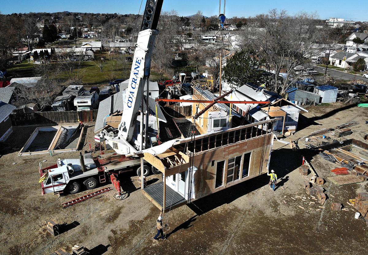 A crane lifts a section of a prefabricated micro house into place in February 2021 for the first phase of the $3.8 million Kennewick Housing Authority project for 16 tiny homes.