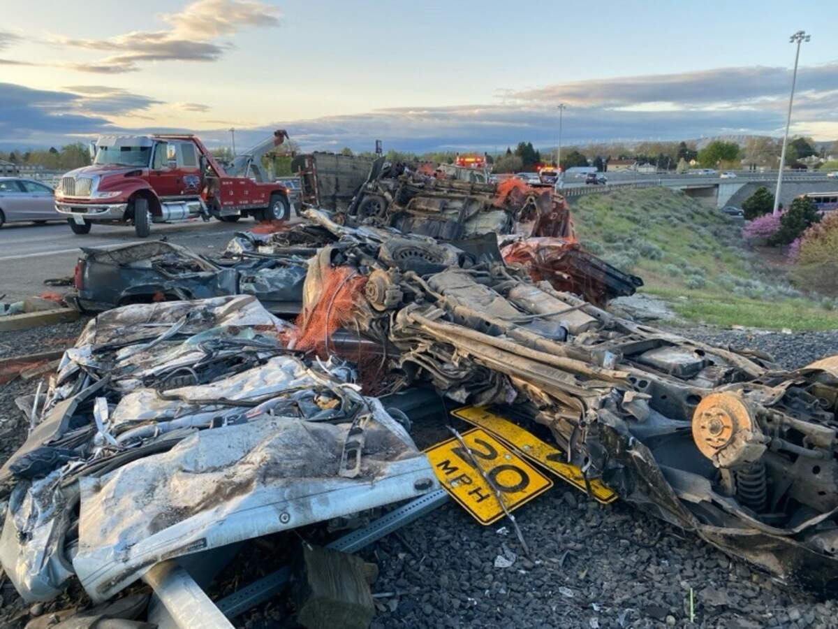 A semi tipped over and left crushed cars on the side of Highway 395 Tuesday.