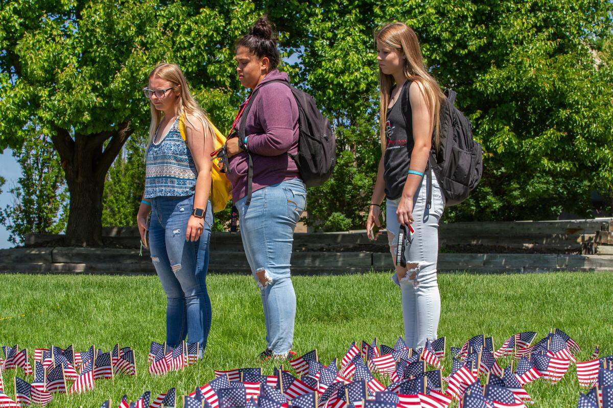 Columbia Basin College students observe a field of 9,088 U.S. flags on Thursday before the start of CBC Memorial Day ceremony. The flags represent the fallen Washington soldiers who died in service, including those who have died from suicide.