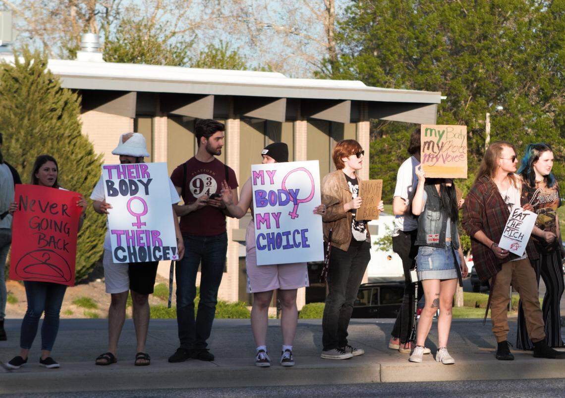 Protesters hold signs reading, “their body, their choice” and “my body, my choice” during a demonstration in support of abortion rights in Richland.