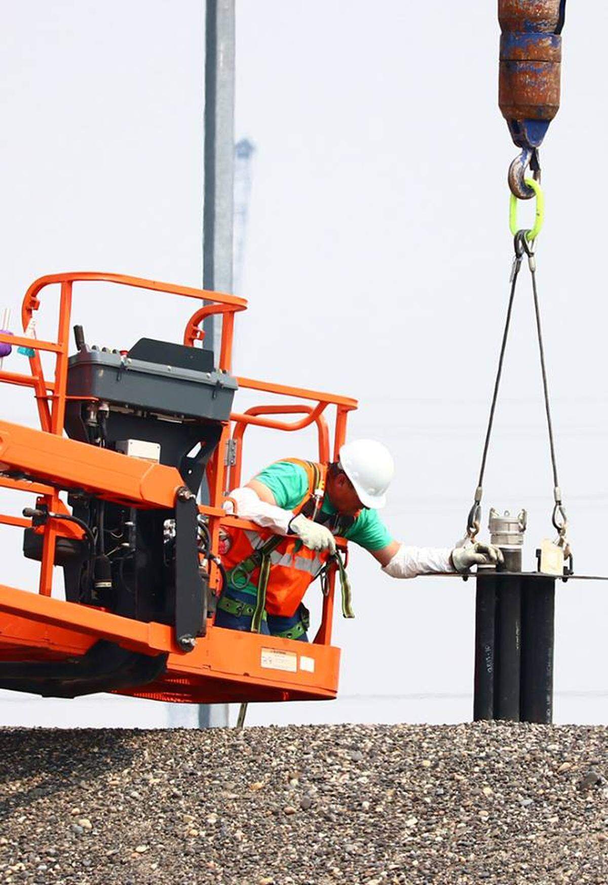 A worker installs equipment in an opening on top of a Hanford radioactive waste storage tunnel that is at risk of collapse. Concrete-like grout will be added through the opening to stabilize the tunnel.