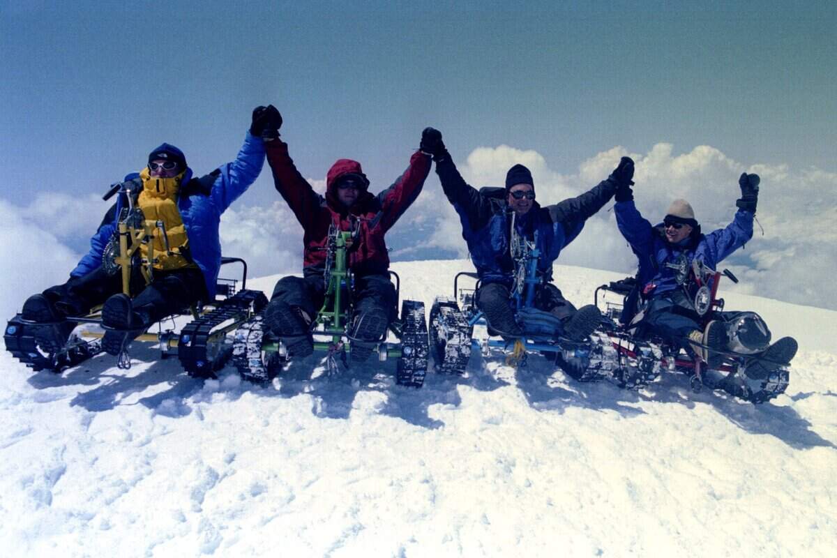 Above: Paraplegic climbers, from left, Mark Wellman, Keegan Reilly, Pete Rieke and Muffy Davis celebrate reaching the summit of Mount Shasta in Northern California. Rieke, of Pasco, joined the other climbers from throughout the West to climb the mountain on hand­cranked snowmobiles, which he and his business partner Greg Coffey built. Below: Rieke, left, and Reilly keep watch for falling rocks at camp as able­bodied climbers make a wall of snow to protect them.