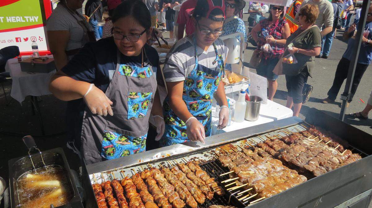 Darlene Baluca and Emmanuel Manaloto with Yakima’s LaSang Pinoy prepare pork and ham skewers during the Food Truck Face-off at Pasco’s Fiery Foods Festival. Saturday’s event featured food trucks, the Pasco Farmer’s Market, a salsa competition and live music as hundreds flocked to downtown Pasco.