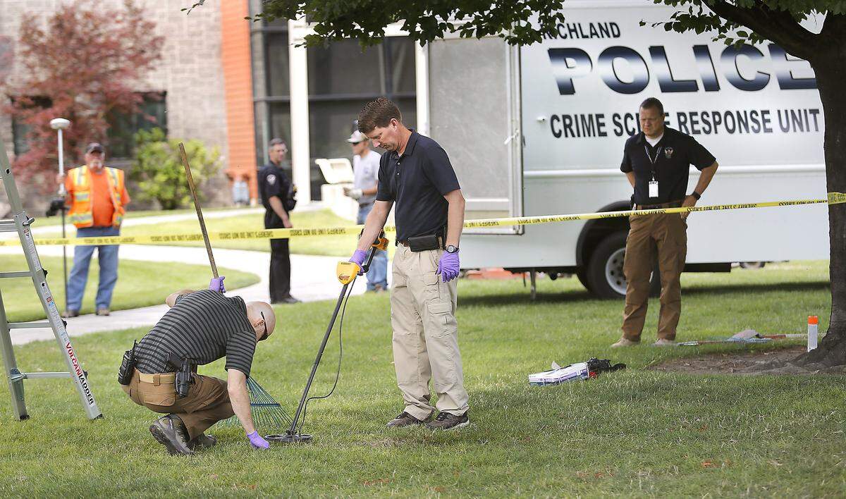 Richland Police Detectives used rakes and a metal detector to search for evidence buried in the ground at the Fourth of July shooting scene in Howard Amon Park. Two suspects have been charged with directing two juvenile males to shoot Sergio Rivera.
