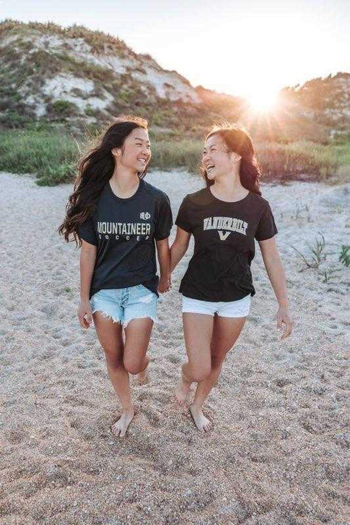 Twin sisters Gracie Rainsberry, left, of Kennewick, Wash., and Audrey Doering, of Wausau, Wis., both 18, pose for photos wearing college T-shirts of where they plan to study after high school. Rainsberry will attend Eastern Oregon University in La Grande, Oregon, while Doering attends Vanderbilt University in Nashville.