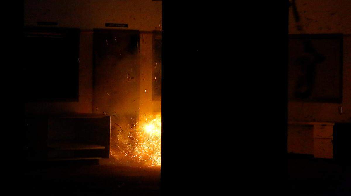 Flames, sparks and debris fill the air as explosives blow a steel frame door from the wall during active shooter training by the Tri-Cities Regional SWAT team at the old Ridgeview Elementary School in Kennewick.