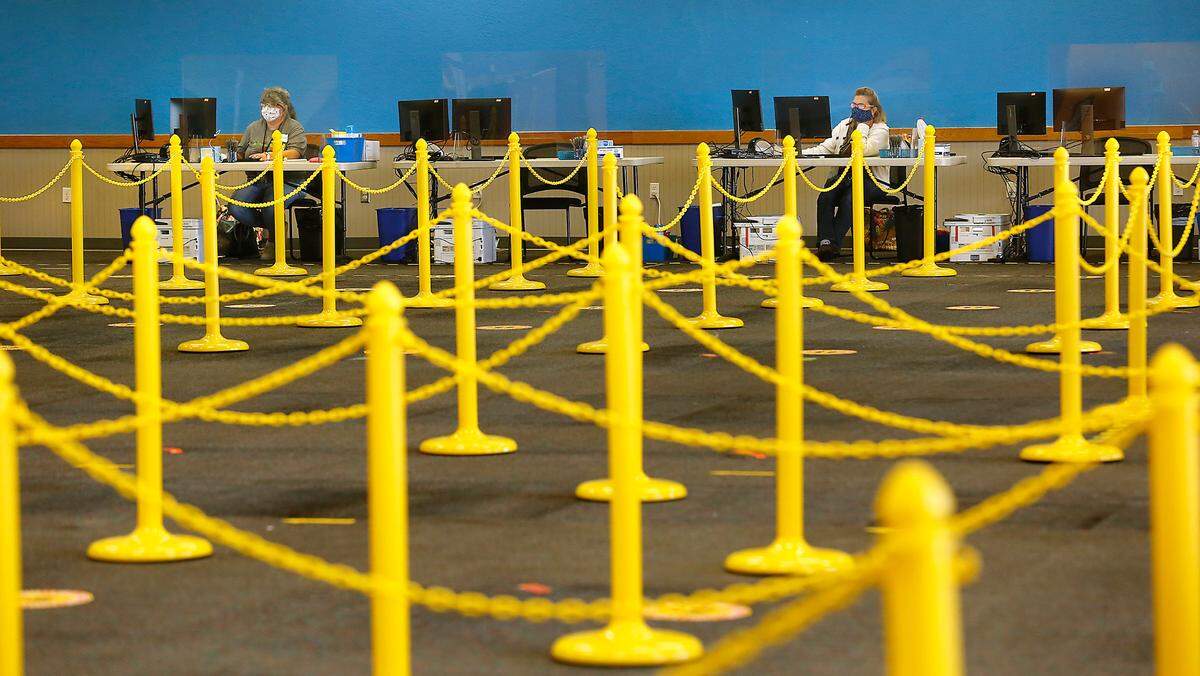 Shawn Bohlinger, left, and Wilma Barton, both Benton County Auditor employees, work at their computer terminals in the newly created voting center on North Columbia Center Blvd. in Richland. Watch a video at: tricityherald.com/videos