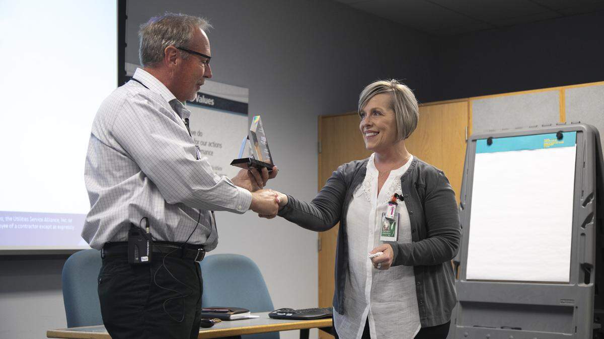 Energy Northwest chief executive Brad Sawatzke gives Cathey Anderson, Energy Northwest occupational health supervisor, a life-saving award at an employee meeting at Columbia Generating Station on Monday.