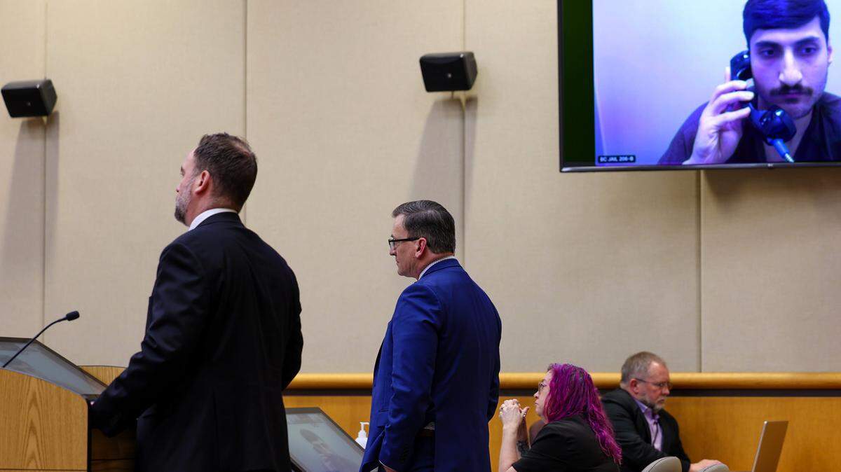 Murder suspect Abdullah A. Hussein appears via a video link in Benton County Superior Court. He plead innocent int the fatal stabbing death of the former boyfriend of the woman he’s dating. Defense attorney Joseph Faurholt, left and Benton Deputy Prosecutor Josh Lilly stand in the foreground.