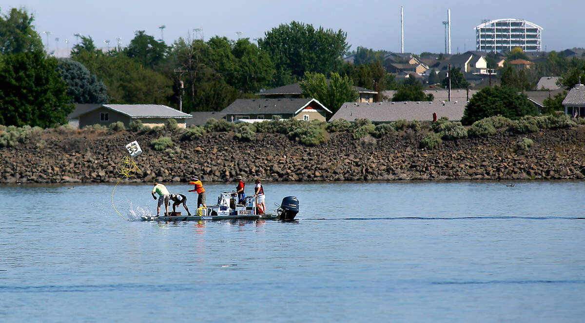 Volunteer members of the Water Follies rescue team drop an anchor point for a marker buoy early Thursday morning for the upper turns of the race course on the Columbia River for Friday’s spring training session. Six racing boats are expected to participate in the practice session in preparation for the upcoming Columbia Cup race in July.