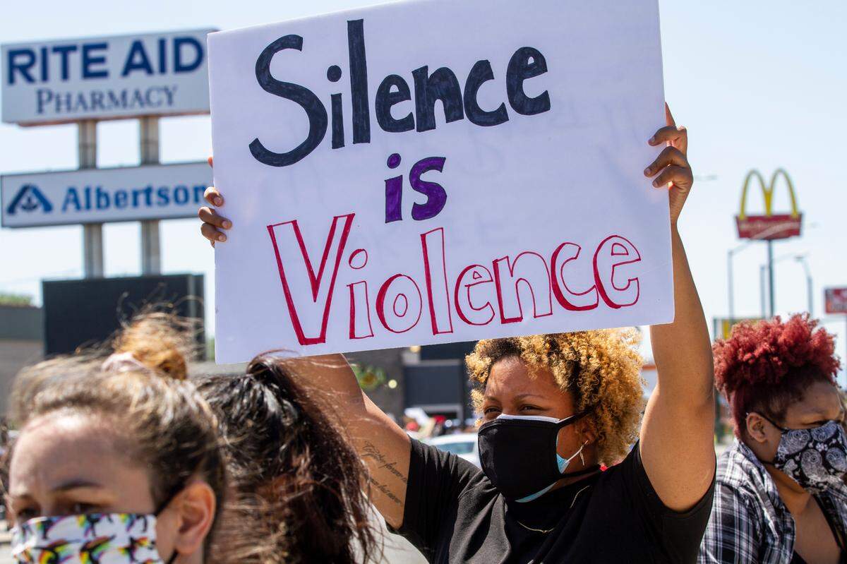 Demonstrators hold signs as cars drive by and honk in solidarity during a peaceful protest against police brutality and violence against black people on Court Street in Pasco on Sunday.