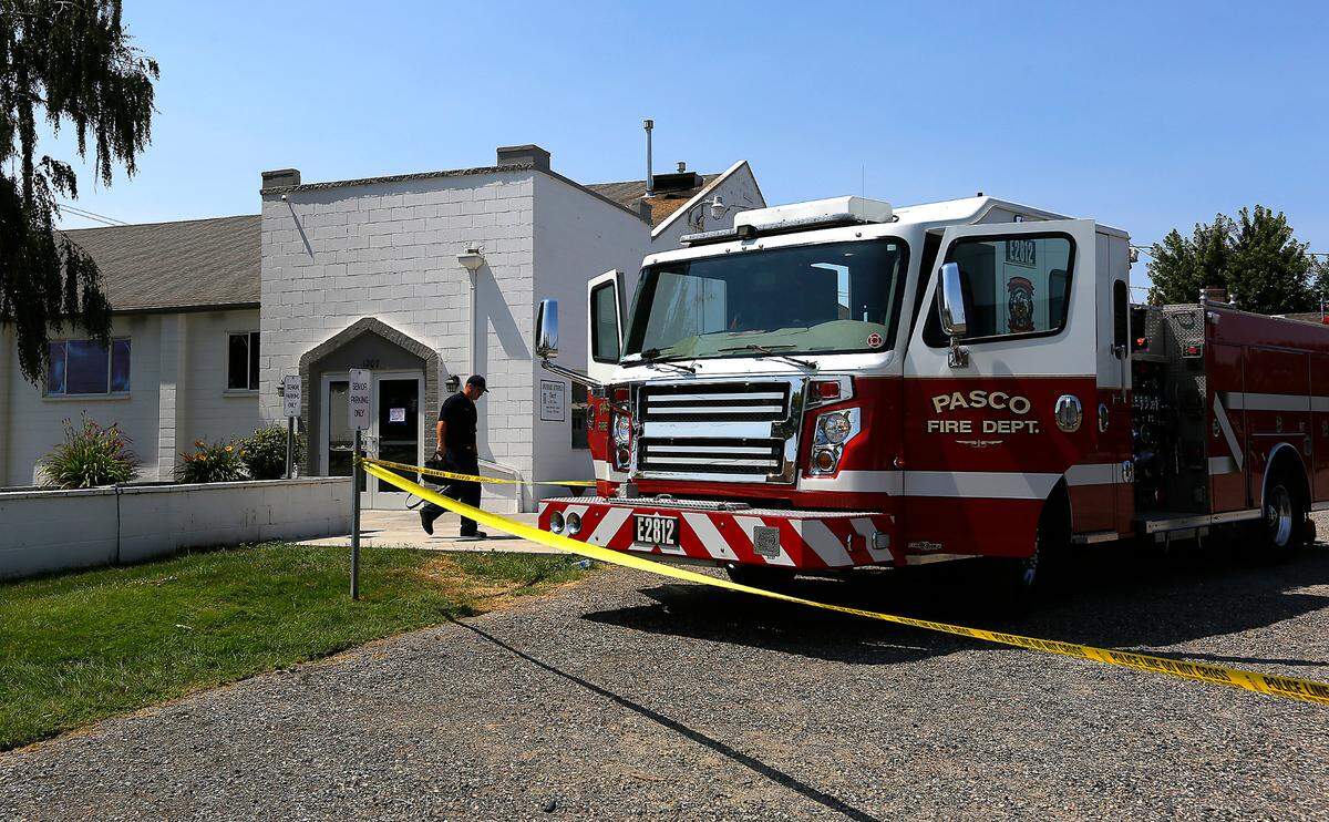 A Pasco fire investigator walks past the burned building at the Apostolic Lutheran Church in Pasco on Thursday.