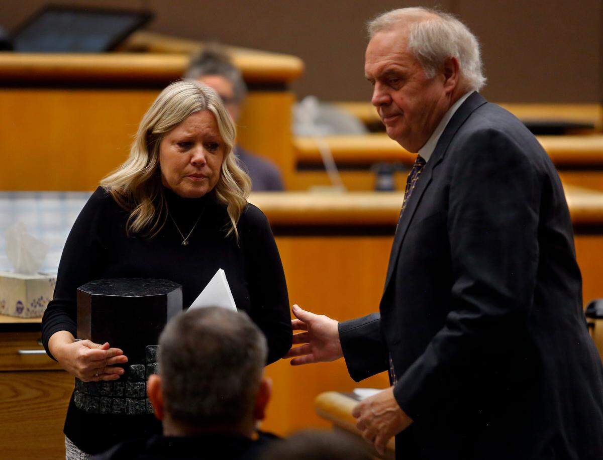 Benton County prosecutor Andy Miller helps widow Kris Mars as she carries an urn containing her husband’s ashes after making a statement at Tuesday morning’s hearing in Benton County Superior Court for convicted murderer Robert Suarez.