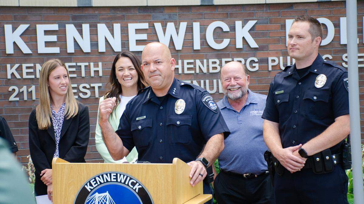 Kennewick Police Chief Chris Guerrero, flanked by officials from HAPO Credit Union and the Kennewick Police Foundation, announce a new joint program allowing police to distribute $100 VISA gift cards.