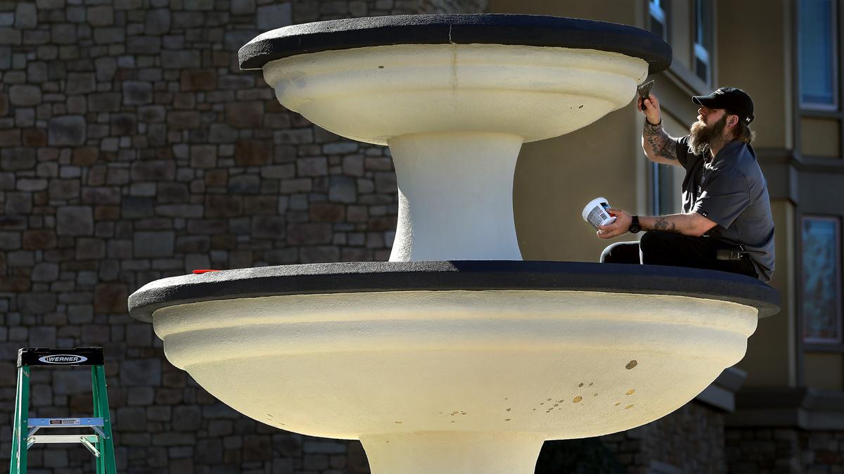 Maintenance worker Reese Groves uses a stucco repair compound to seal the fountain at Homewood Suites by Hilton at 1060 George Washington Way in Richland. The centerpiece spray fountain is scheduled to be repainted.