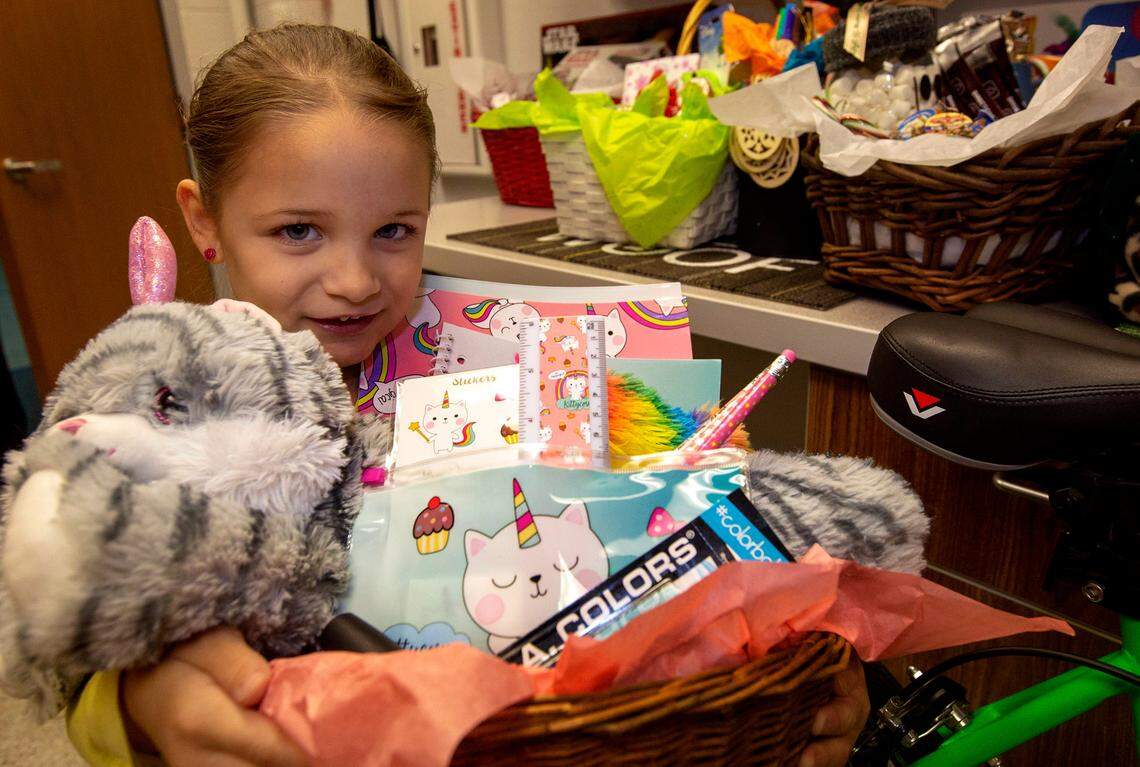 In December 2018, kindergarten student Genie Hernandez holds her favorite basket that she helped put together her school’s Santa Breakfast and silent auction fundraiser.