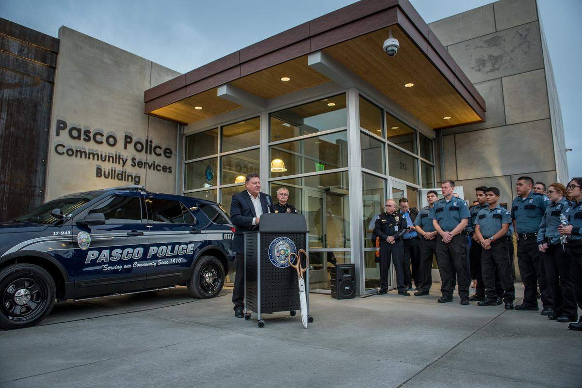 Pasco City Manager Dave Zabell addresses the audience at the February 2017 dedication of the new Pasco Community Services Building as Pasco Chief of Police Bob Metzger and members of the Pasco Police Explorers look on.