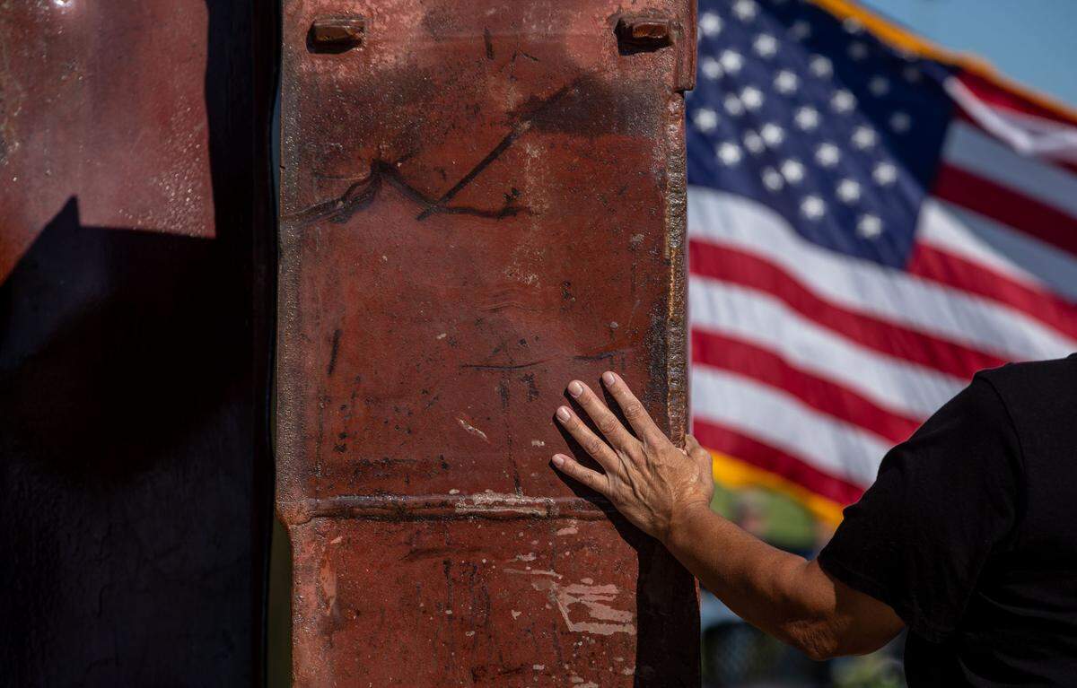 Leticia Zavala, of Richland, places her hand on the 9/11 Memorial in Kennewick in a moment of quiet remembrance before a ceremony commemorating the 20th anniversary of the terrorist attacks that killed thousands on Sept. 11, 2001.