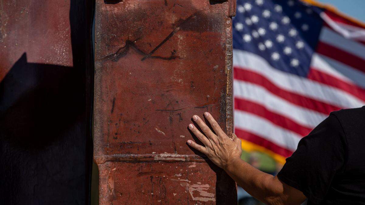 Leticia Zavala, of Richland, places her hand on the 9/11 Memorial in Kennewick in a moment of quiet remembrance before a ceremony commemorating the 20th anniversary of the terrorist attacks that killed thousands on Sept. 11, 2001. The Tri-Cities is one of a few communities in the U.S. to receive a piece of steel from the World Trade Center.