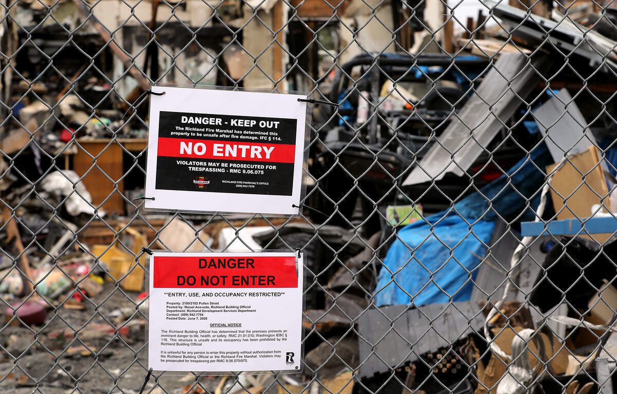 A temporary construction fence surrounds the burned remnants of the "junkyard" house on Pullen Street in Richland.