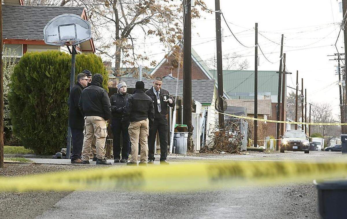 Pasco police investigators and Franklin Prosecutor Shawn Sant, left, stand on North Sixth Avenue near the alley between West Clark and Bonneville Streets during the investigation of the fatal stabbing of Demetrius A. Graves in February 2018.