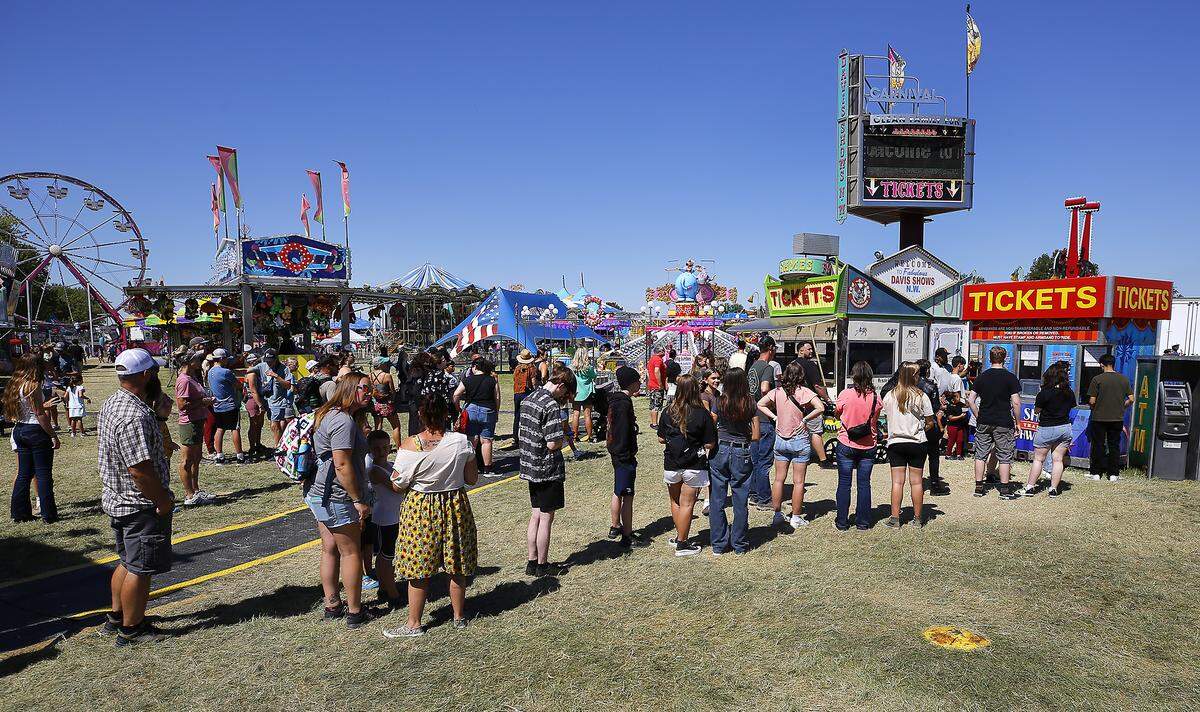 Riders wait in line to by tickets Friday afternoon to the Davis Shows Northwest carnival area at the Benton Franklin Fair & Rodeo in Kennewick.