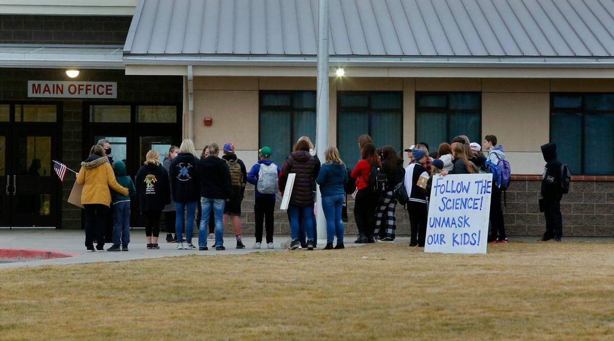 Mask choice student protesters and their parents meet with school administrators in front of the main entrance to Enterprise Middle School at the start of school Monday in West Richland. Students choosing not to wear masks to class inside the building were walked around to the back of the buildings near portable classrooms and kept outside.